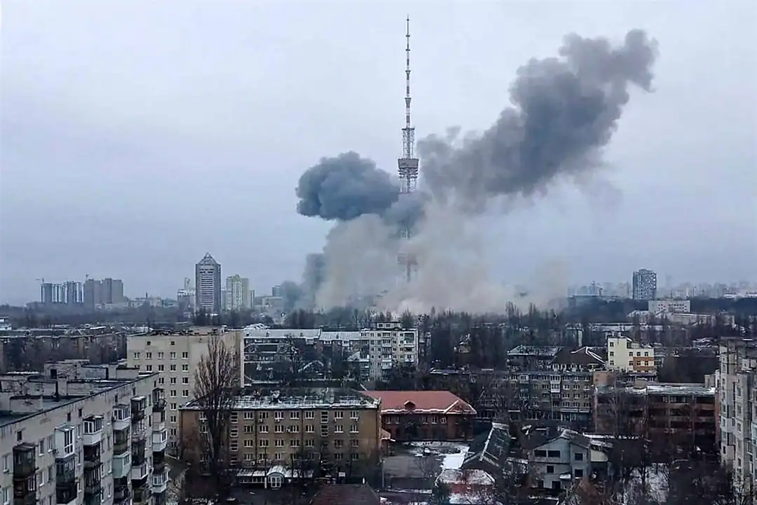 A large smoke plume rising from an explosion near the Kyiv TV tower during the war, seen over residential apartment blocks.