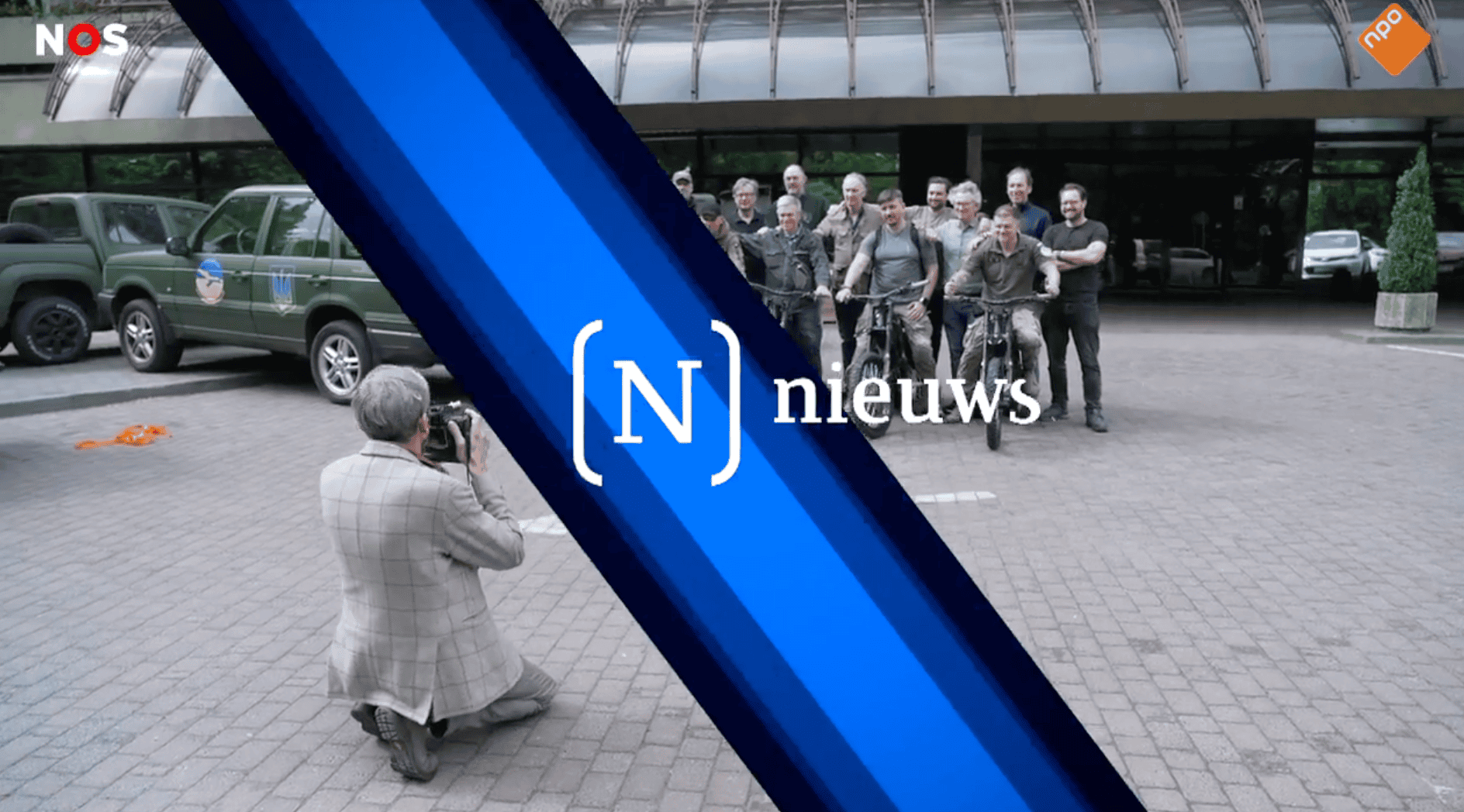 Still from the NOS Journaal news broadcast showing Protect Ukraine volunteers being photographed, featuring the NOS News banner.