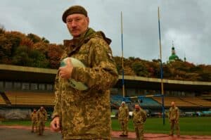 Eddy van Wessel photograph of a military service member holding a rugby ball during a match between soldiers and Protect Ukraine.