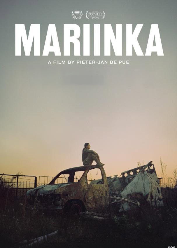 A film poster for the documentary 'MARIINKA'. The poster features a striking image at twilight, with a solitary figure in military-style clothing sitting thoughtfully on the roof of a heavily damaged and burnt-out pickup truck. The vehicle is surrounded by overgrown weeds and a derelict metal fence in a barren landscape, against a gradient sky of muted blues and warm oranges. At the top, in large bold white capitals, is the film title 'MARIINKA'. Above the title are laurel wreath logos, including a central one for 'DOCVILLE 2026'. Below the title, the text reads 'A FILM BY PIETER-JAN DE PUE'. A small 'vpro' logo is at the bottom right.